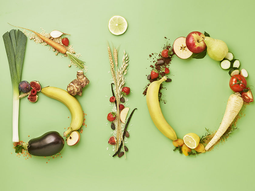 Le mot "BIO" écrit à l’aide de fruits et légumes frais, disposés sur un fond vert, symbolisant l’alimentation saine et naturelle.